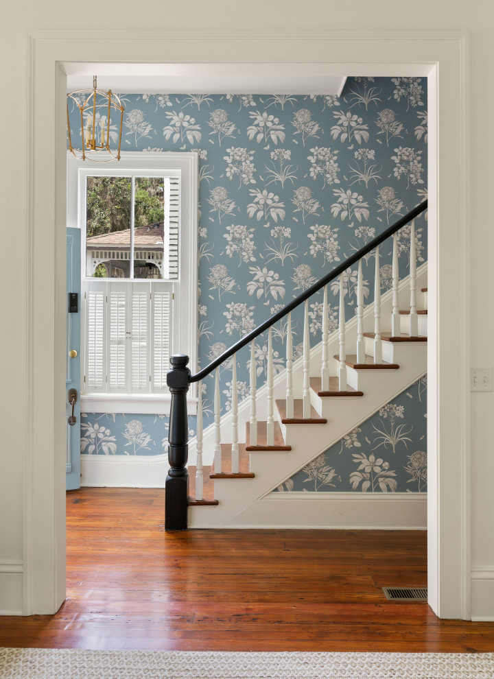 Photo of a mid-sized traditional wood straight staircase in Atlanta with wood risers, wood railing and wallpaper.
