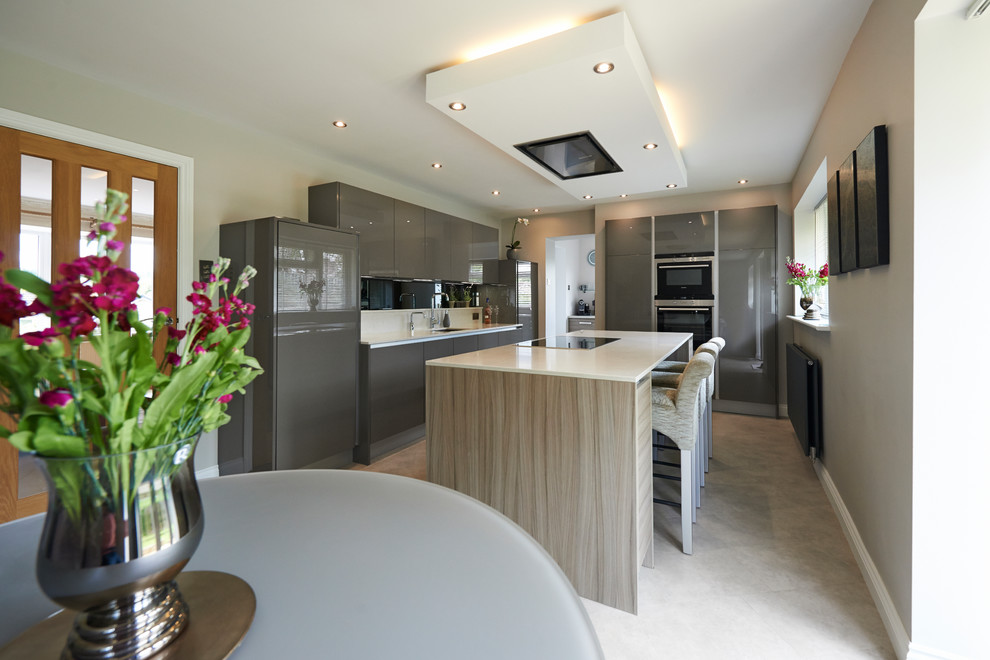 Inspiration for a contemporary l-shaped kitchen in Other with flat-panel cabinets, grey cabinets, white splashback, with island, grey floor and white benchtop.