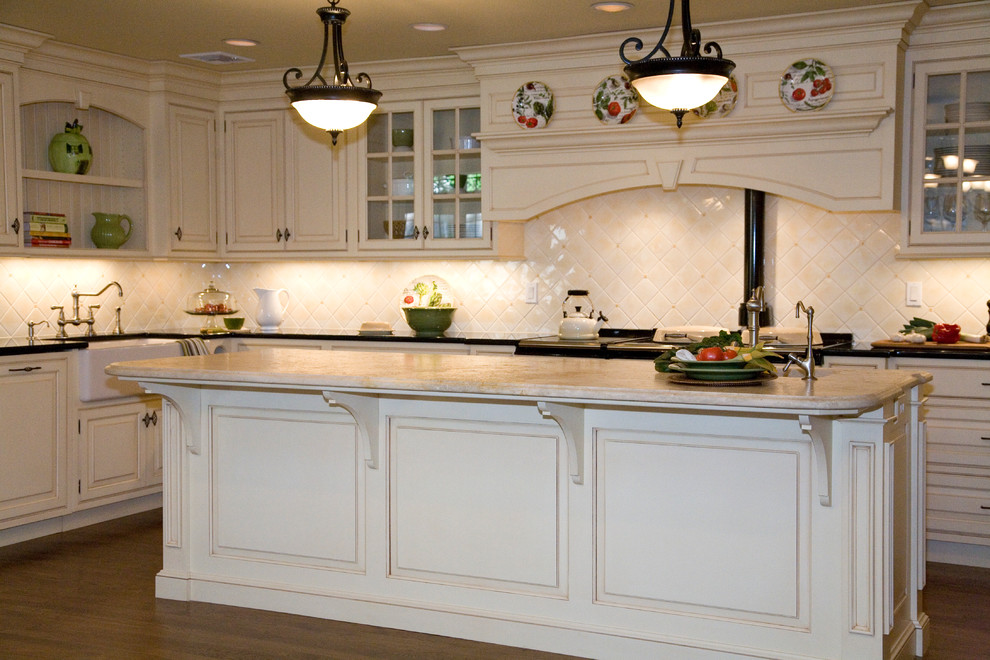 This is an example of a traditional u-shaped kitchen in New York with a farmhouse sink, beaded inset cabinets, beige cabinets, marble benchtops, beige splashback, ceramic splashback and white appliances.