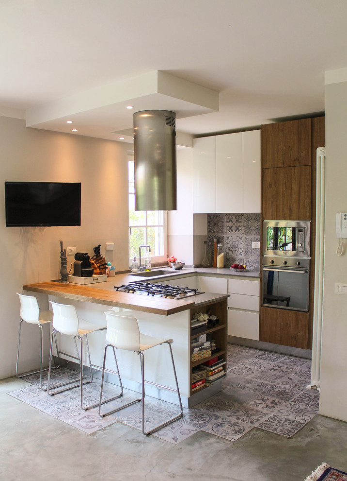 Mid-sized contemporary u-shaped kitchen in Other with an undermount sink, flat-panel cabinets, dark wood cabinets, ceramic splashback, concrete floors, a peninsula, grey splashback, stainless steel appliances and grey floor.
