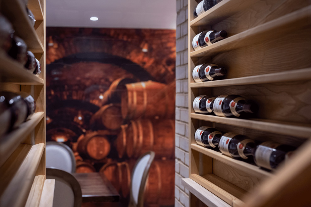 This is an example of a medium sized classic wine cellar in London with display racks.