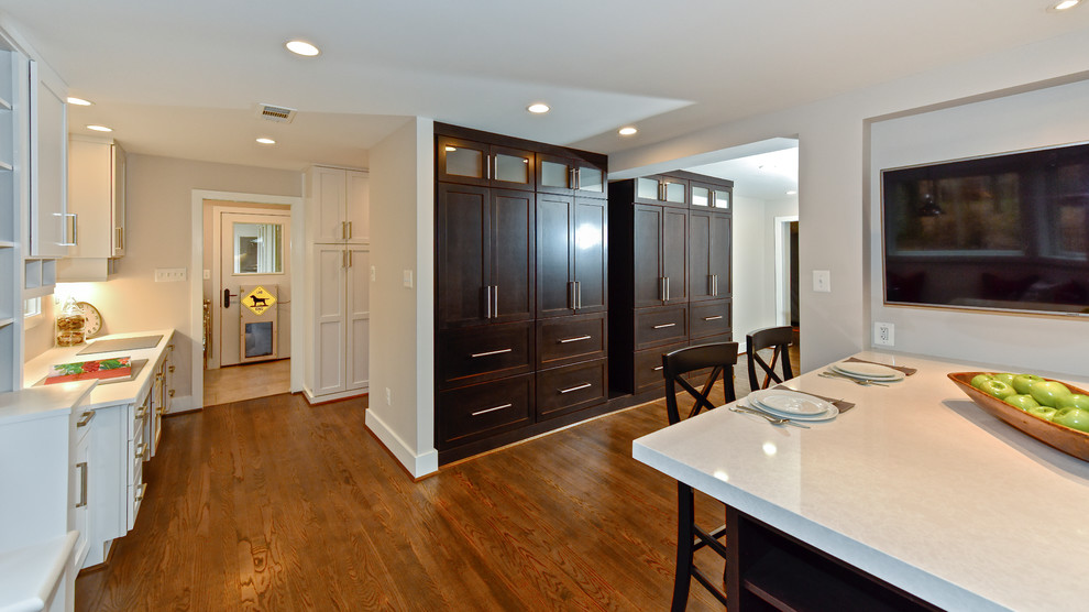 This is an example of a large transitional u-shaped kitchen pantry in DC Metro with an undermount sink, shaker cabinets, dark wood cabinets, quartz benchtops, multi-coloured splashback, slate splashback, stainless steel appliances, medium hardwood floors and multiple islands.