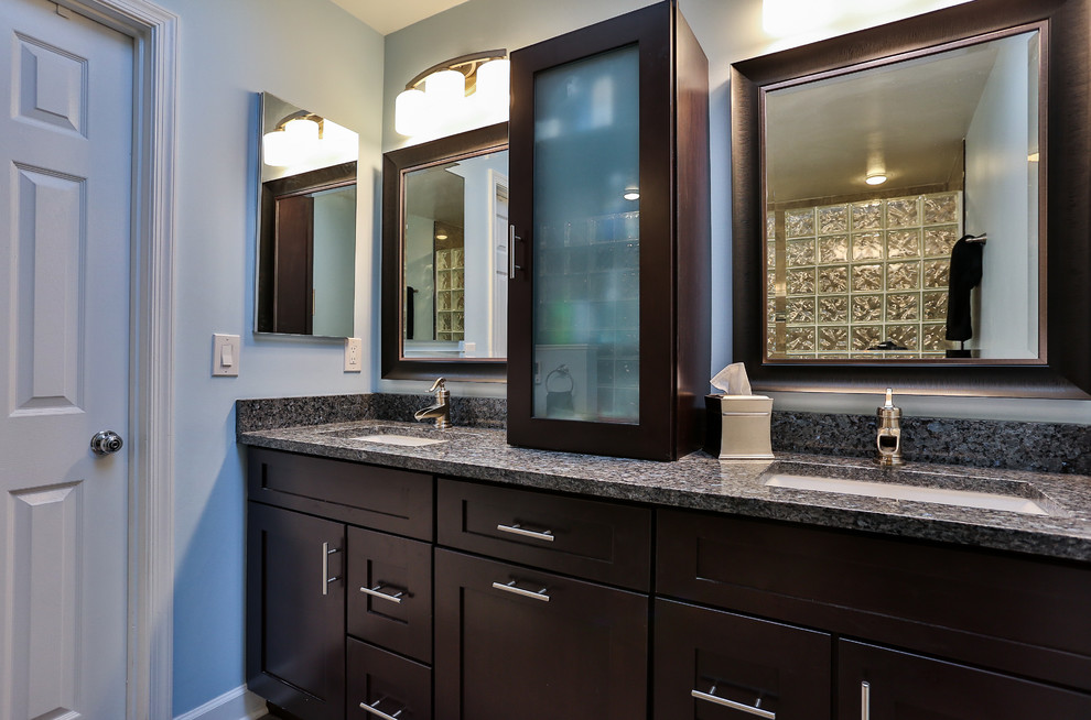 Photo of a large traditional master bathroom in DC Metro with shaker cabinets, dark wood cabinets, an alcove shower, a two-piece toilet, gray tile, porcelain tile, grey walls, porcelain floors, an undermount sink, granite benchtops and grey benchtops.