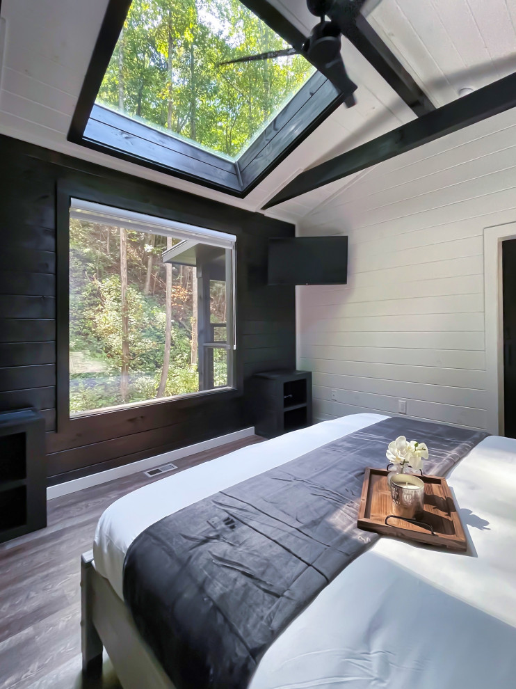 Großes Modernes Hauptschlafzimmer mit weißer Wandfarbe, dunklem Holzboden, braunem Boden, freigelegten Dachbalken und Holzdielenwänden in Houston