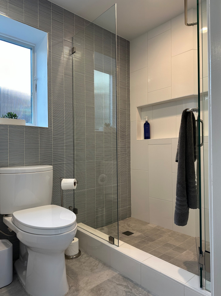 Foto på ett litet funkis vit badrum med dusch, med släta luckor, vita skåp, en dusch i en alkov, grå kakel, glaskakel, klinkergolv i keramik, ett undermonterad handfat, bänkskiva i akrylsten, grått golv och dusch med gångjärnsdörr