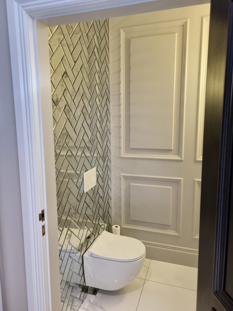 Small transitional bathroom in Other with a wall-mount toilet, mirror tile, grey walls, marble floors, a vessel sink, white floor, a single vanity and decorative wall panelling.