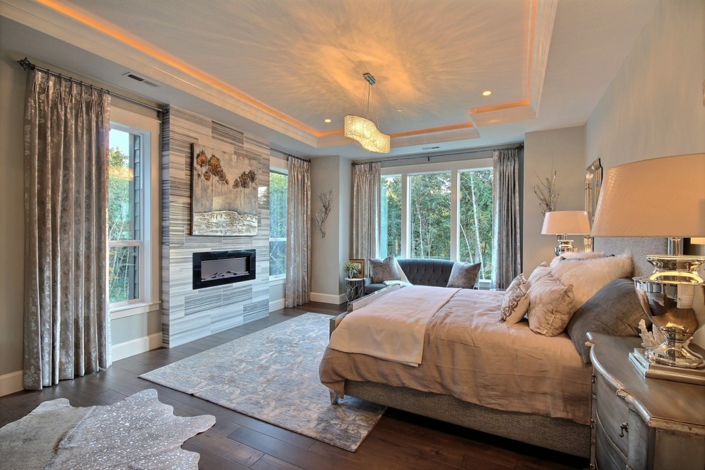 Large transitional master bedroom in Portland with grey walls, dark hardwood floors, a ribbon fireplace and a stone fireplace surround.