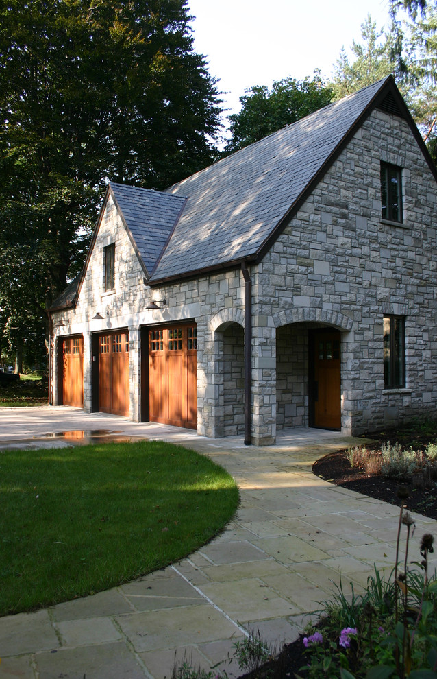 This is an example of a mid-sized traditional detached three-car garage in Other.
