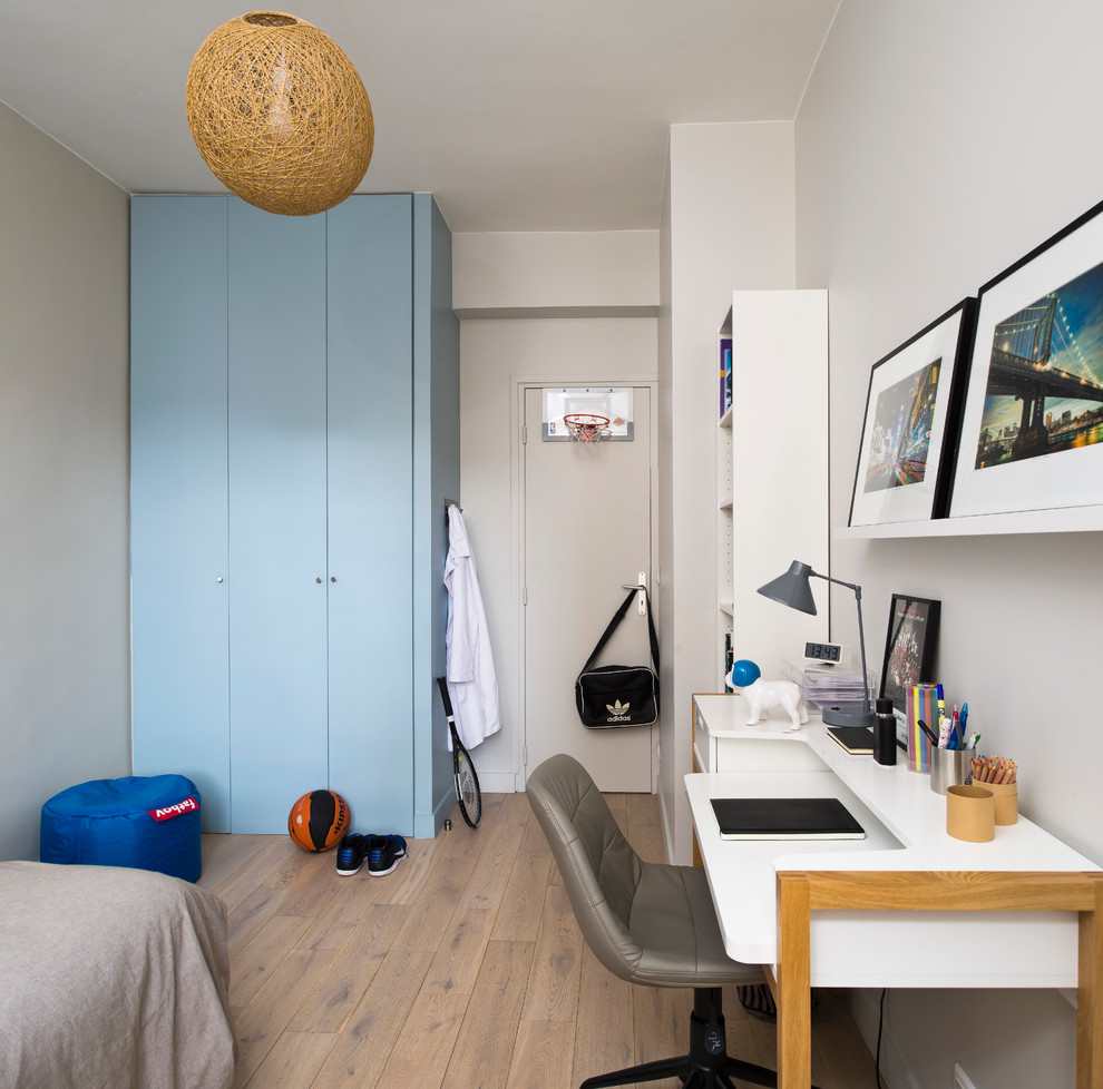 Contemporary kids' room in Paris with white walls, light hardwood floors and beige floor for boys.