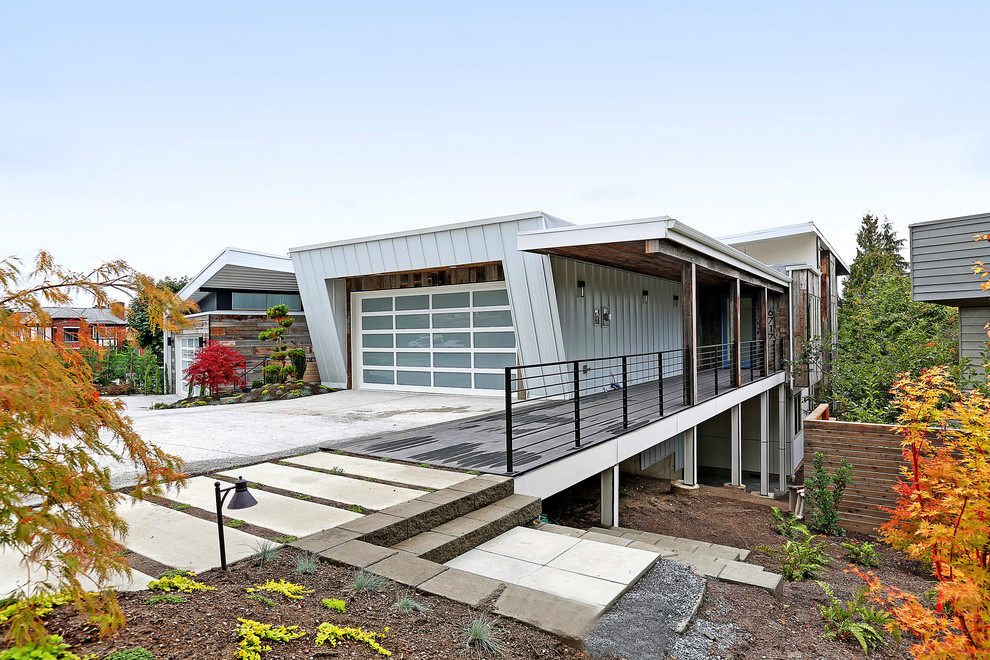 Contemporary two-storey grey house exterior in Seattle with mixed siding, a flat roof and a metal roof.