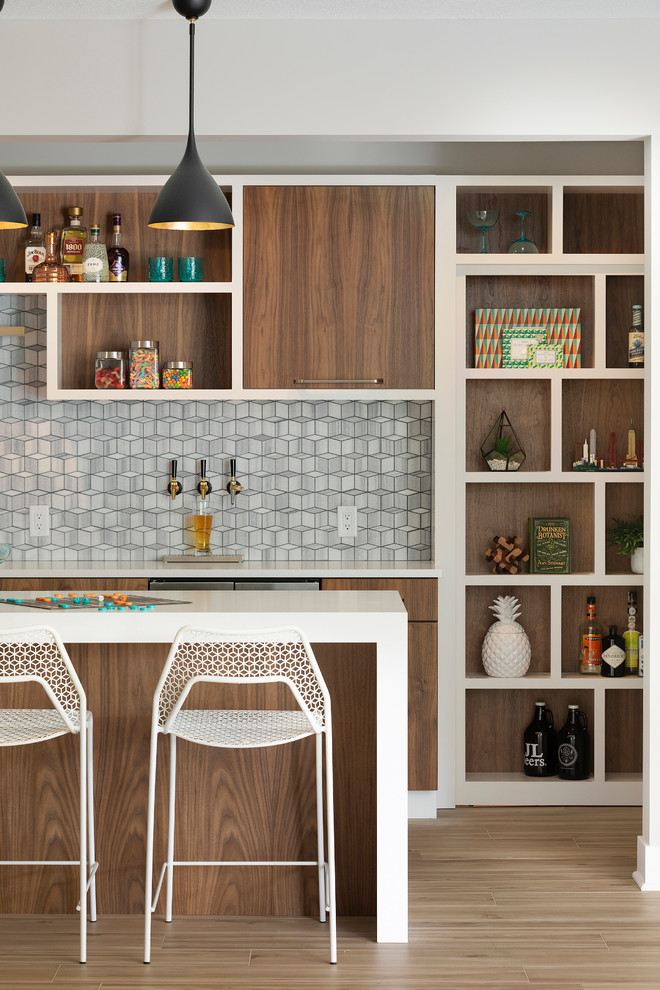 Mid-sized contemporary galley seated home bar in Minneapolis with an undermount sink, flat-panel cabinets, medium wood cabinets, quartz benchtops, grey splashback, marble splashback, porcelain floors, beige floor and white benchtop.
