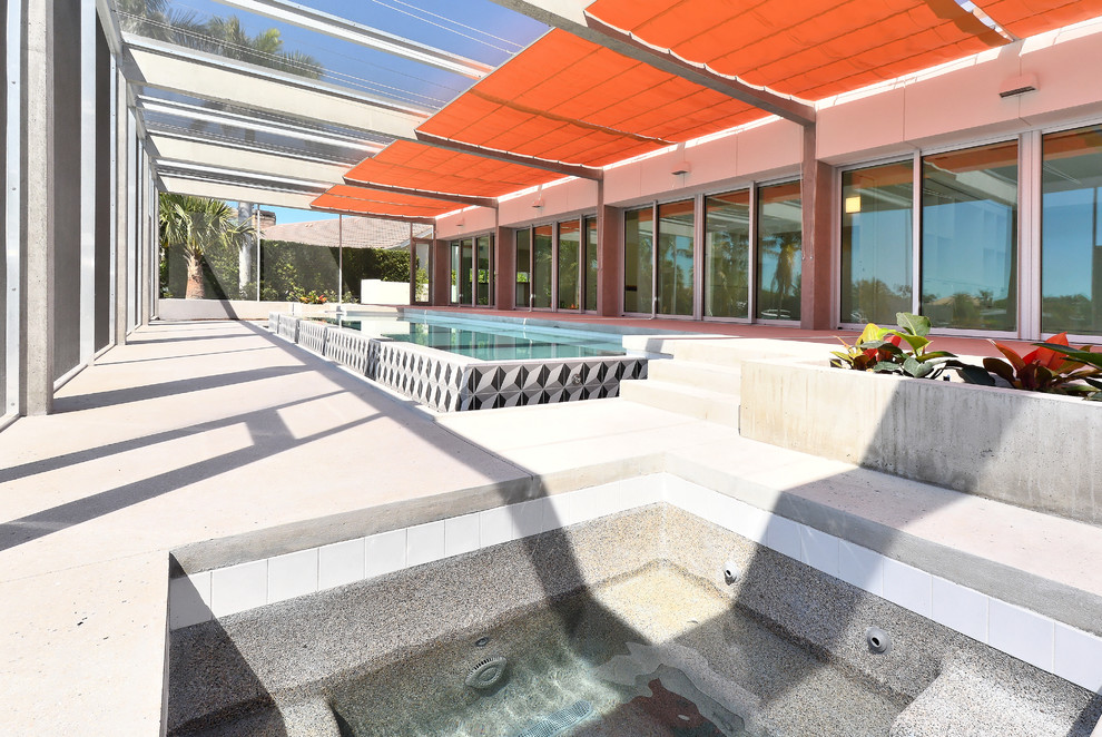 Inspiration for a mid-sized modern backyard rectangular lap pool in Tampa with tile.