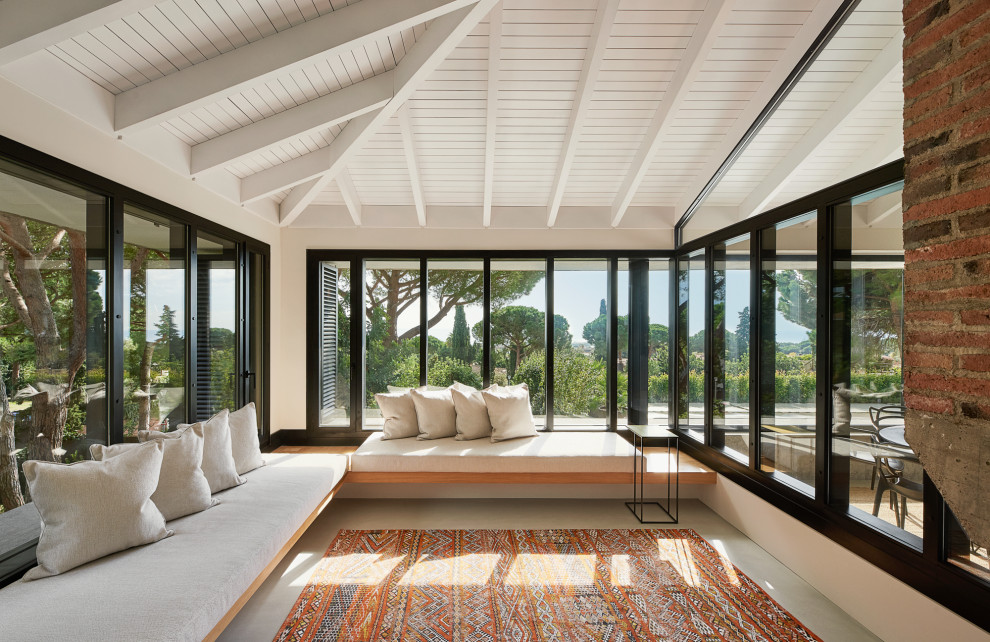 Photo of a large modern sunroom in Barcelona with a corner fireplace and a concrete fireplace surround.