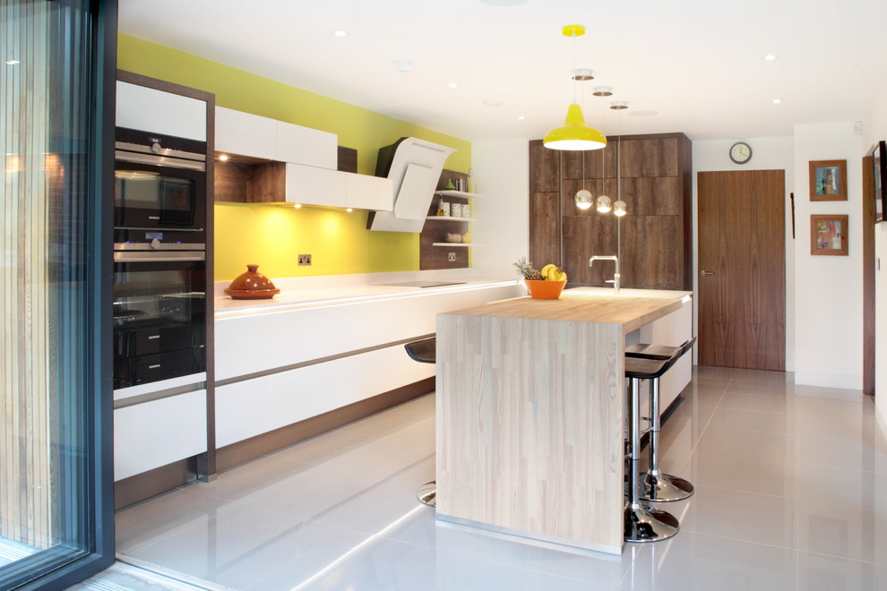 Design ideas for a mid-sized contemporary l-shaped open plan kitchen in Buckinghamshire with glass sheet splashback, stainless steel appliances, with island, yellow splashback, porcelain floors, an undermount sink, flat-panel cabinets, white cabinets and quartzite benchtops.