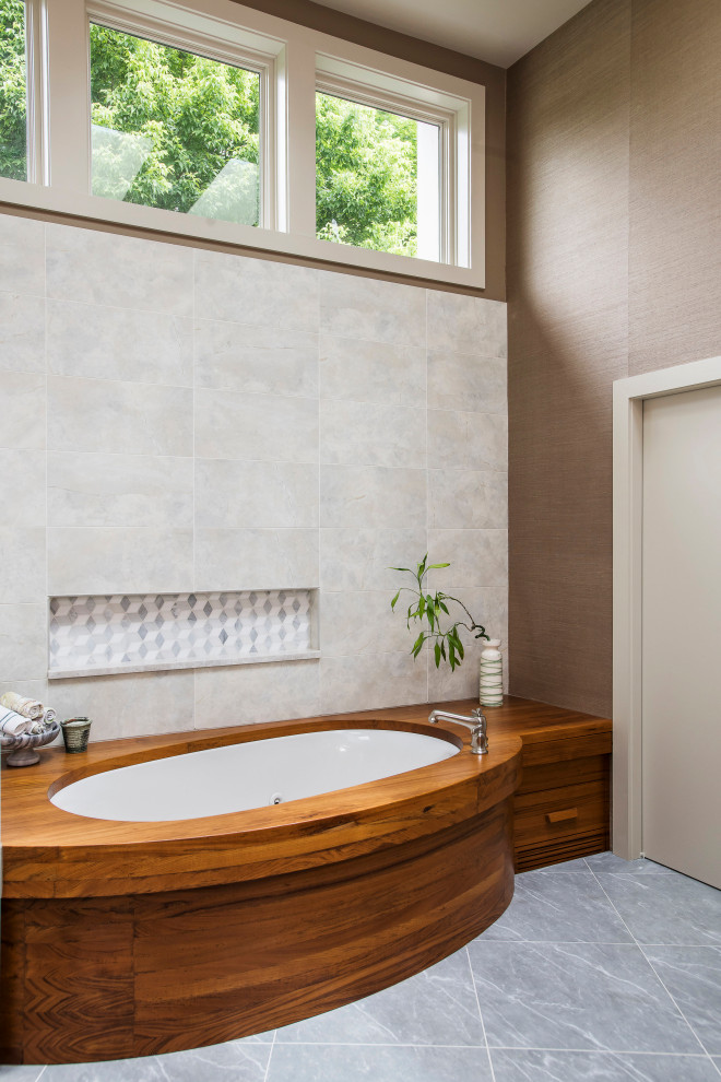 Стильный дизайн: главная ванная комната в стиле модернизм с полновстраиваемой ванной, белой плиткой, керамической плиткой, коричневыми стенами, полом из керамической плитки и серым полом - последний тренд