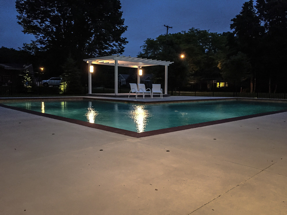 Inspiration for a large contemporary backyard l-shaped pool in Grand Rapids with a pool house and natural stone pavers.