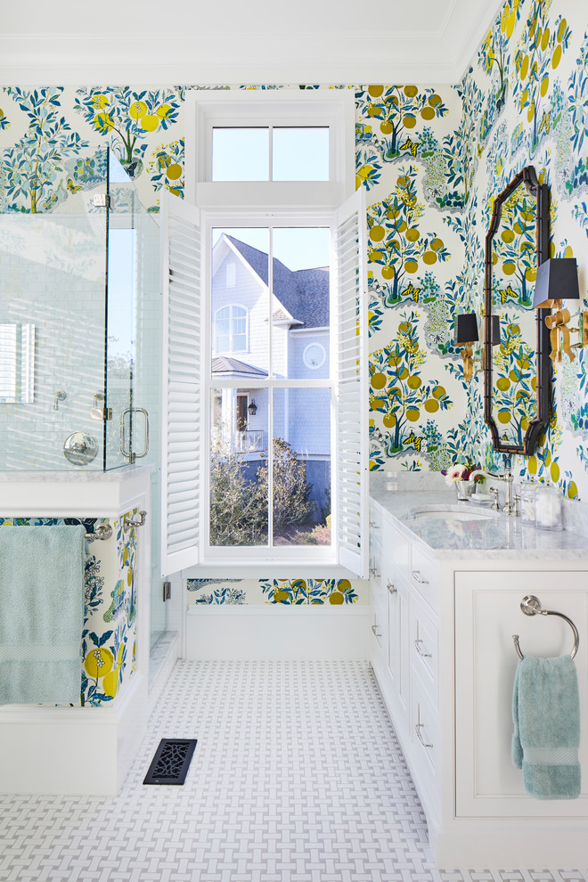 Design ideas for a beach style master bathroom in Charleston with beaded inset cabinets, white cabinets, a corner shower, white tile, porcelain tile, multi-coloured walls, porcelain floors, an undermount sink, marble benchtops, white floor, a hinged shower door and grey benchtops.
