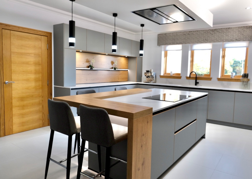 Offene, Große Moderne Küche mit grauen Schränken, schwarzen Elektrogeräten, Kücheninsel und weißer Arbeitsplatte in Sonstige