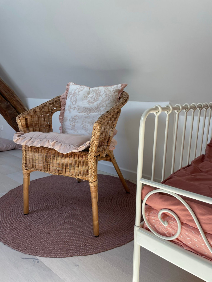 Aménagement d'une grande chambre d'enfant de 1 à 3 ans scandinave en bois avec un mur beige, parquet clair, un sol beige et poutres apparentes.