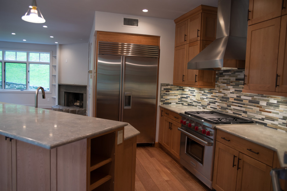 Example of a large transitional l-shaped medium tone wood floor eat-in kitchen design with a double-bowl sink, recessed-panel cabinets, medium tone wood cabinets, concrete countertops, multicolored backsplash, matchstick tile backsplash, stainless steel appliances and an island