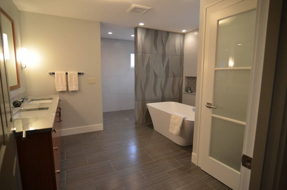 Photo of a large contemporary master bathroom in Portland with an undermount sink, flat-panel cabinets, dark wood cabinets, wood benchtops, a freestanding tub, an open shower, gray tile, stone tile, grey walls and marble floors.