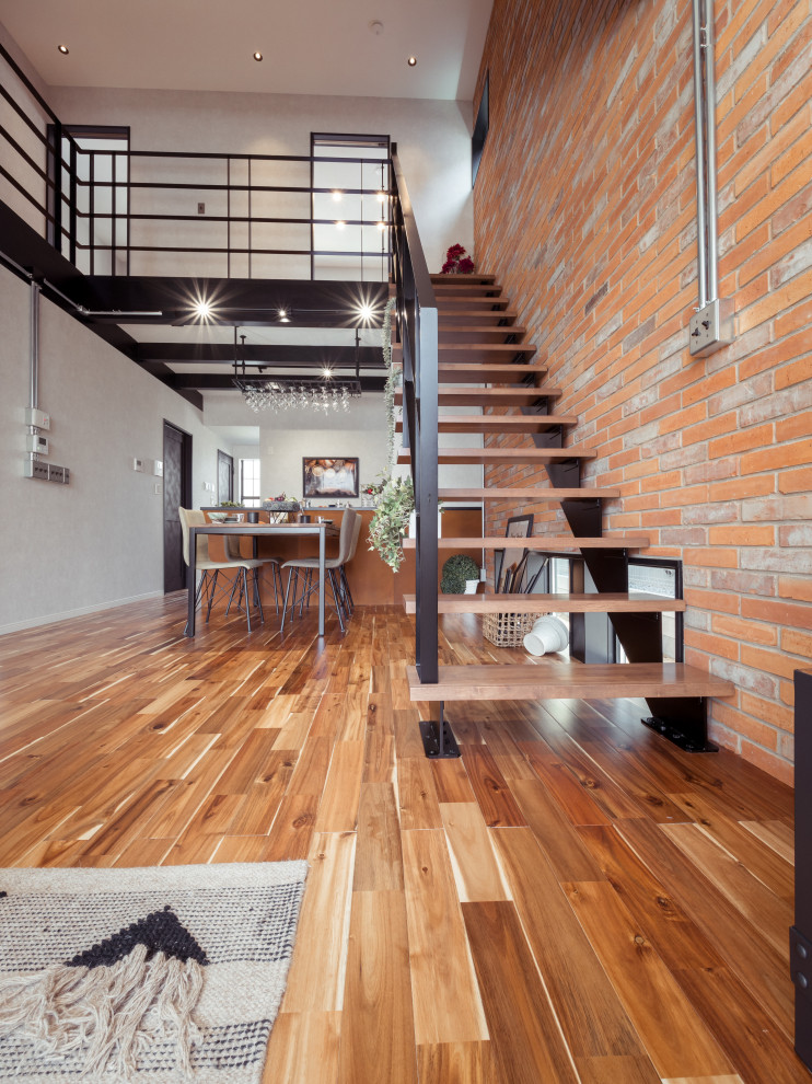 Medium sized modern wood straight metal railing staircase in Other with brick walls.