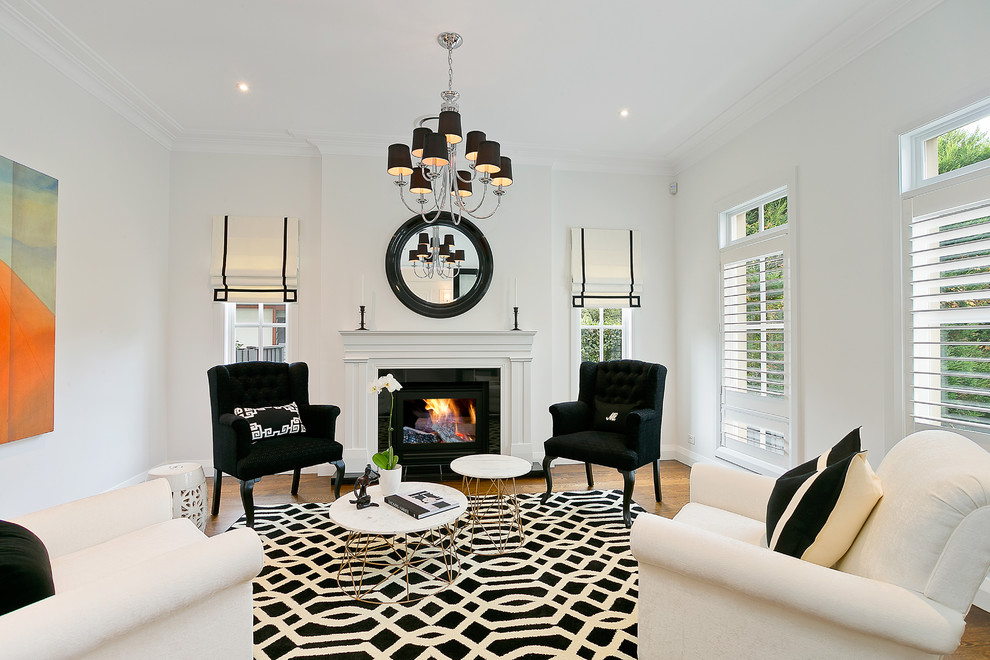 Photo of a mid-sized contemporary formal enclosed living room in Sydney with white walls, medium hardwood floors, a standard fireplace and a wood fireplace surround.