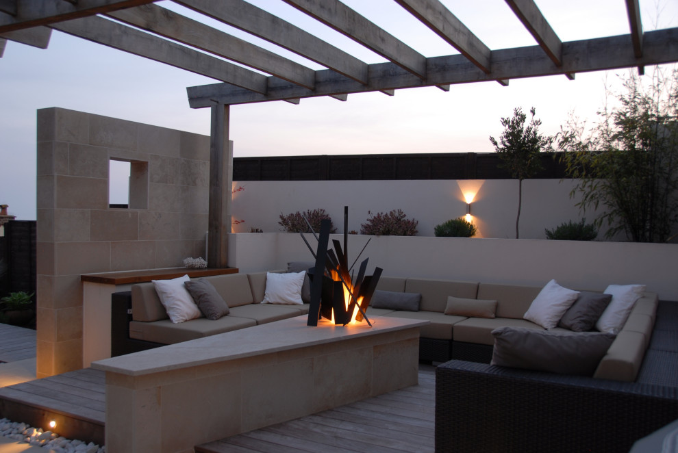 Design ideas for a small contemporary rooftop deck in Devon with with fireplace and a pergola.