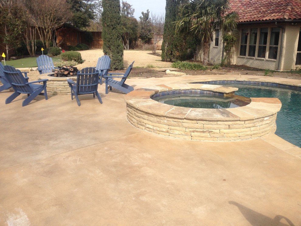 Hot tub - large rustic backyard stamped concrete and custom-shaped natural hot tub idea in Dallas