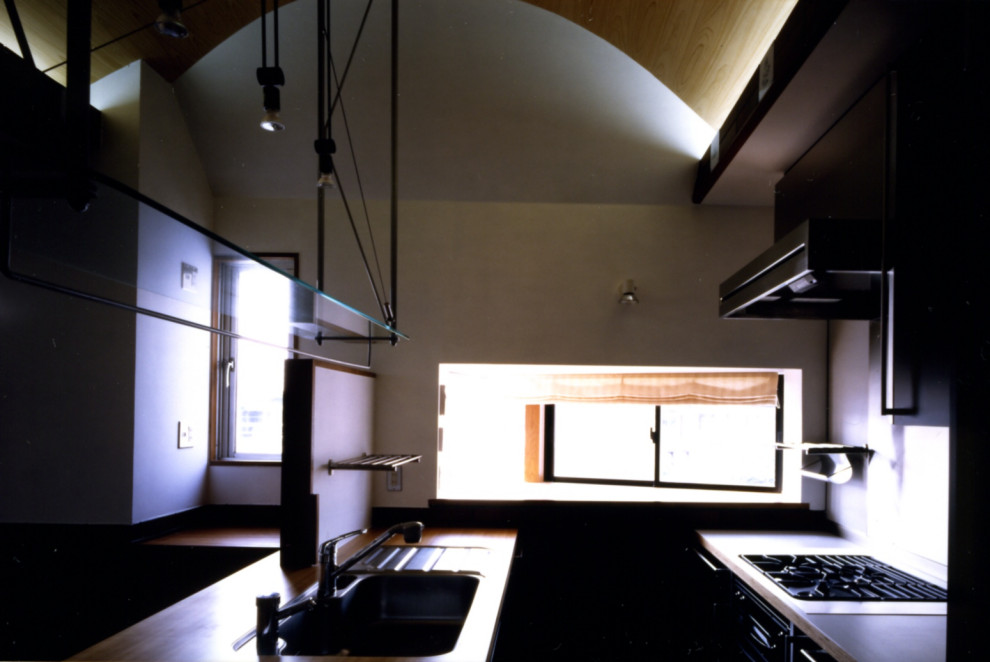 Idéer för ett litet modernt brun kök, med en undermonterad diskho, luckor med profilerade fronter, gröna skåp, träbänkskiva, stänkskydd med metallisk yta, rostfria vitvaror, mellanmörkt trägolv, en köksö och brunt golv