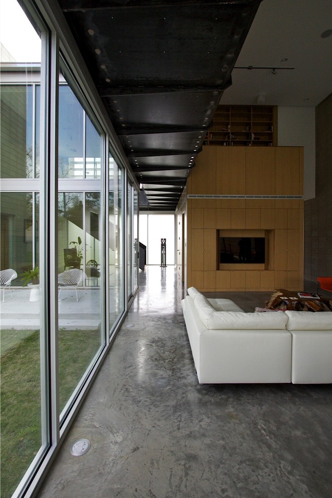 This is an example of a contemporary living room in Houston with concrete floors and grey floor.
