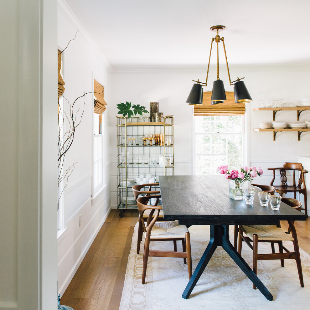 Photo of a scandinavian separate dining room in Sacramento with white walls, medium hardwood floors and brown floor.