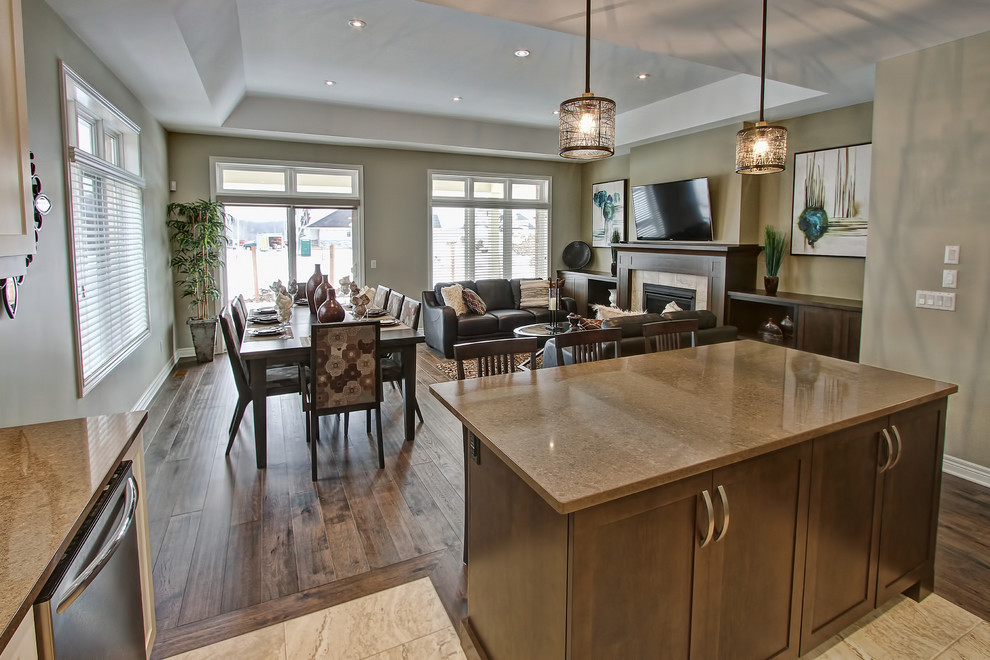 Inspiration for a large transitional l-shaped limestone floor open concept kitchen remodel in Toronto with an undermount sink, shaker cabinets, white cabinets, granite countertops, white backsplash, glass tile backsplash, stainless steel appliances and an island