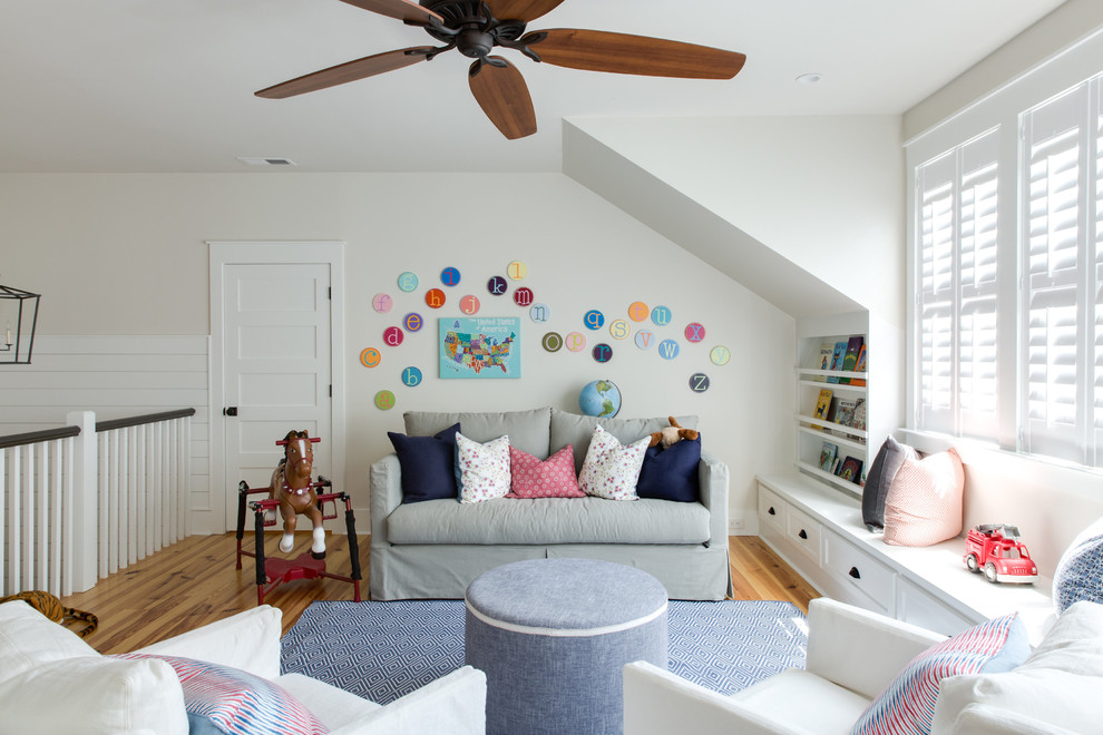 This is an example of a transitional gender-neutral kids' playroom for kids 4-10 years old in Charleston with white walls and medium hardwood floors.