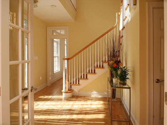 Inspiration for a transitional hallway in Dallas with yellow walls and light hardwood floors.