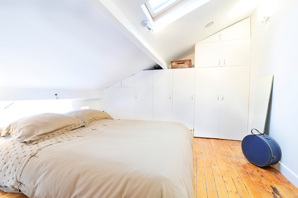 Photo of a small contemporary bedroom in Paris with white walls, light hardwood floors and no fireplace.
