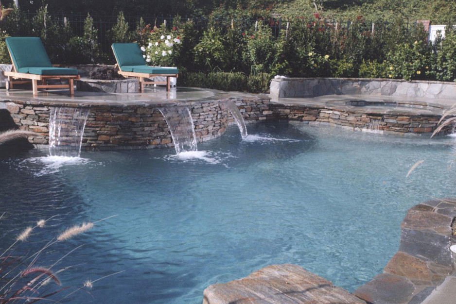 Mid-sized traditional backyard custom-shaped lap pool in Orange County with a hot tub and concrete slab.