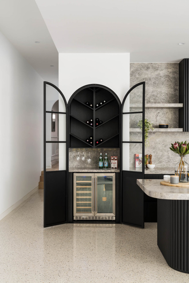 Design ideas for a large contemporary l-shaped home bar in Melbourne with black cabinets, marble benchtops, grey splashback, marble splashback, concrete floors, grey floor and grey benchtop.
