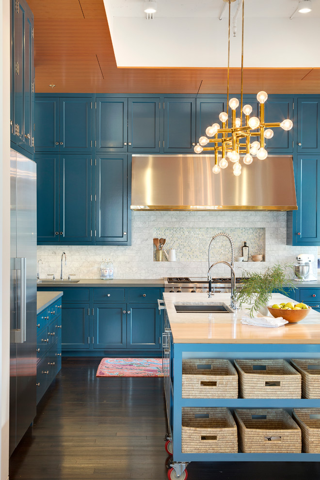 Inspiration for a large transitional l-shaped eat-in kitchen in Minneapolis with a double-bowl sink, recessed-panel cabinets, blue cabinets, marble benchtops, white splashback, stone tile splashback, stainless steel appliances, with island and dark hardwood floors.