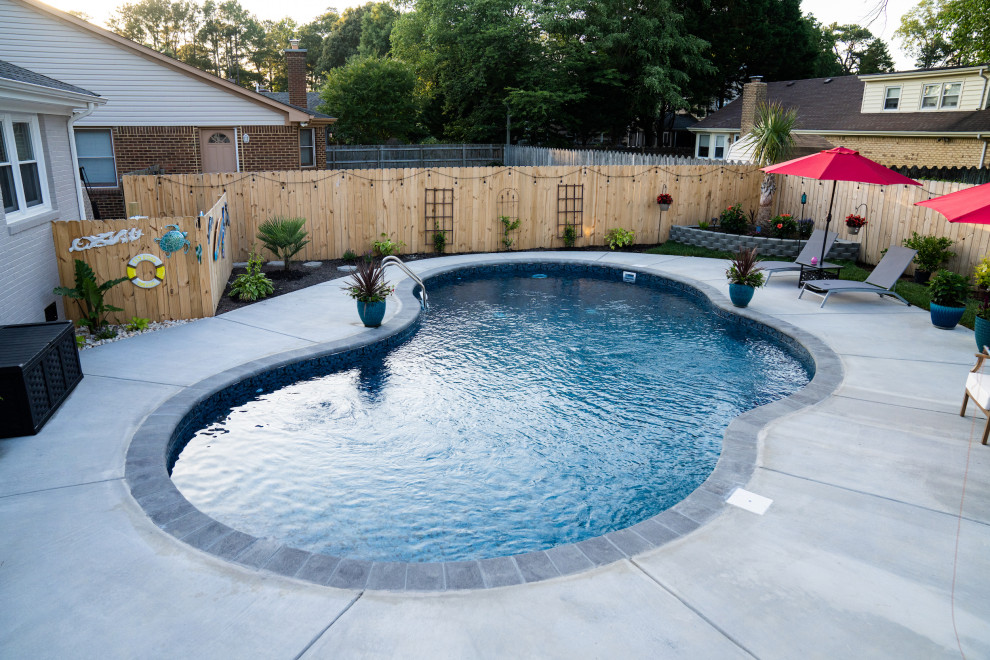 Esempio di una piscina monocorsia costiera a "C" di medie dimensioni e dietro casa con paesaggistica bordo piscina e lastre di cemento