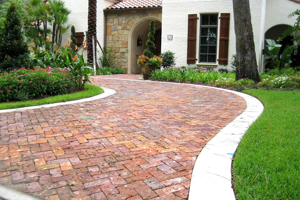 Inspiration for a large traditional front yard full sun driveway for summer in San Diego with brick pavers.