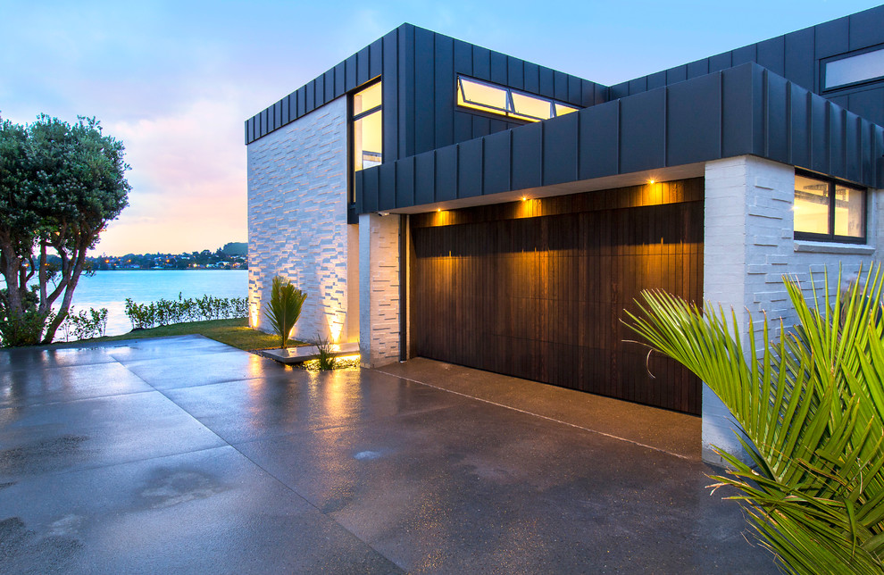 Large contemporary two-storey house exterior in Auckland with mixed siding and a flat roof.