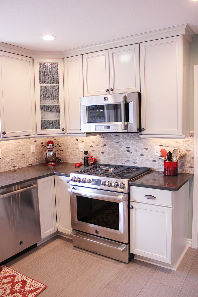 Example of a large transitional u-shaped enclosed kitchen design with a double-bowl sink, shaker cabinets, white cabinets, granite countertops, multicolored backsplash, stainless steel appliances and a peninsula