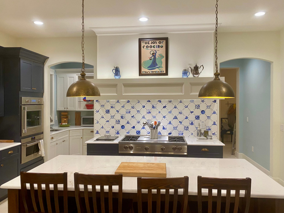 На фото: огромная кухня в стиле кантри с синим фартуком, фартуком из керамической плитки и техникой из нержавеющей стали с