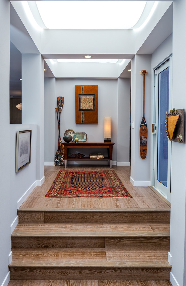 Inspiration for a mid-sized midcentury entry hall in Los Angeles with grey walls, medium hardwood floors, a double front door and a black front door.