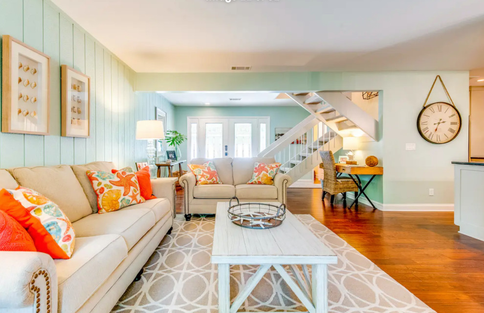 Mid-sized beach style open concept living room in Other with blue walls, medium hardwood floors and brown floor.