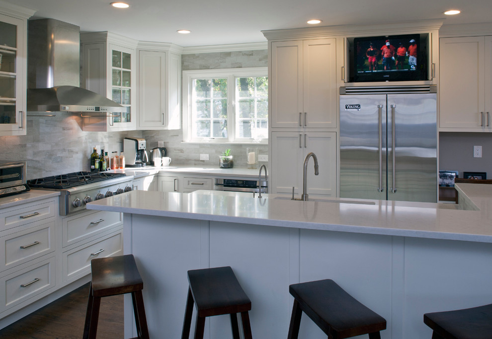 Inspiration for a transitional l-shaped open concept kitchen remodel with an undermount sink, shaker cabinets, white cabinets, quartz countertops, gray backsplash, porcelain backsplash and stainless steel appliances