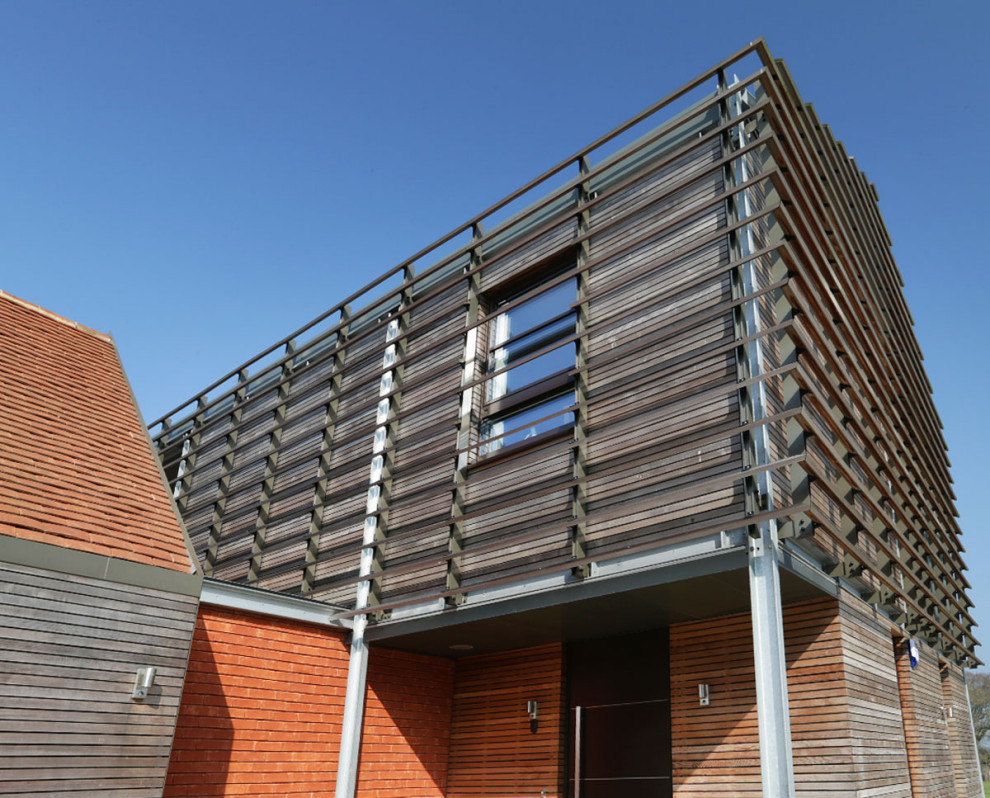 Imagen de fachada de casa moderna grande de dos plantas con revestimiento de madera