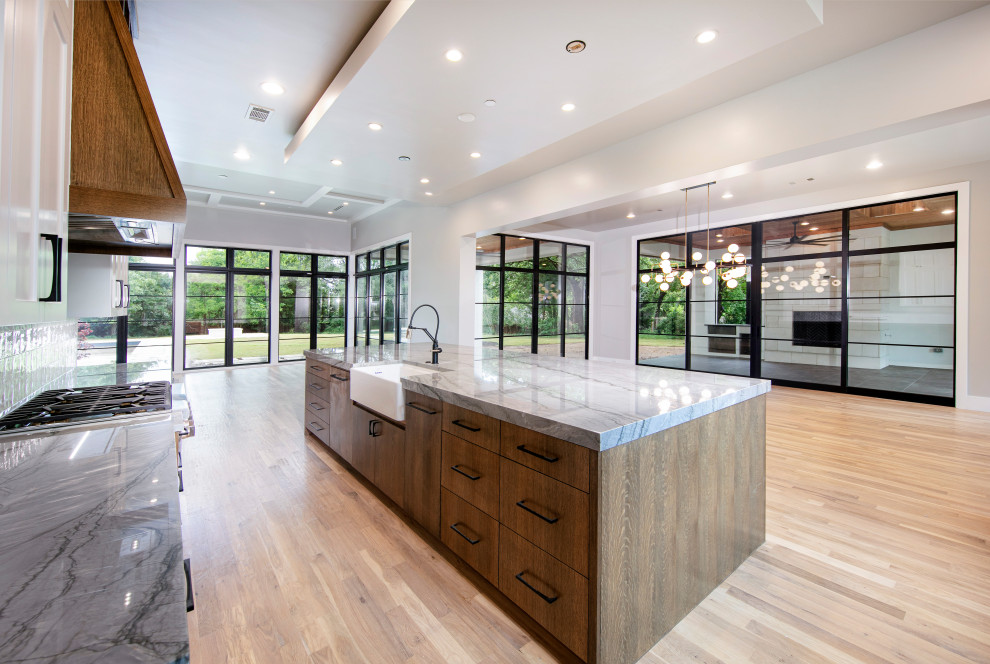 Example of a large transitional u-shaped eat-in kitchen design in Dallas with flat-panel cabinets, dark wood cabinets, quartz countertops, white backsplash, stainless steel appliances, an island and gray countertops