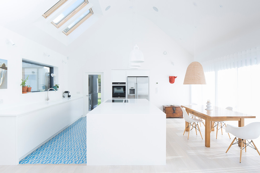 Inspiration for a contemporary eat-in kitchen in Other with flat-panel cabinets, white cabinets, stainless steel appliances, cement tiles and with island.